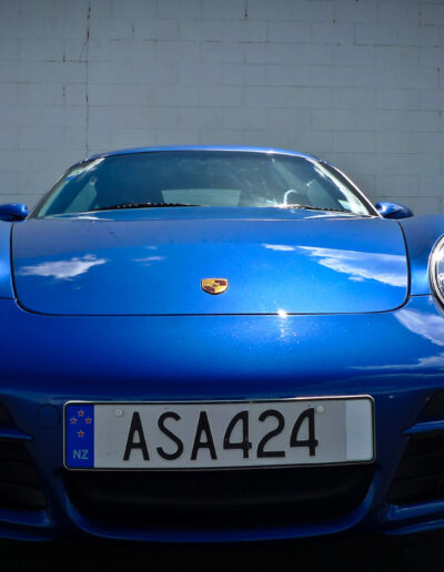 Close up of front bumper and bonnet with clouds reflecting on surface